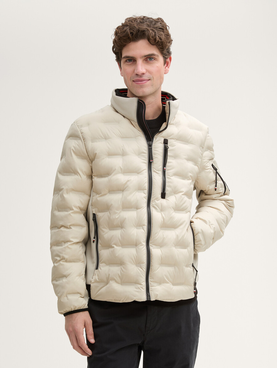 chaqueta acolchada ligera híbrida con capucha y cuello alto.