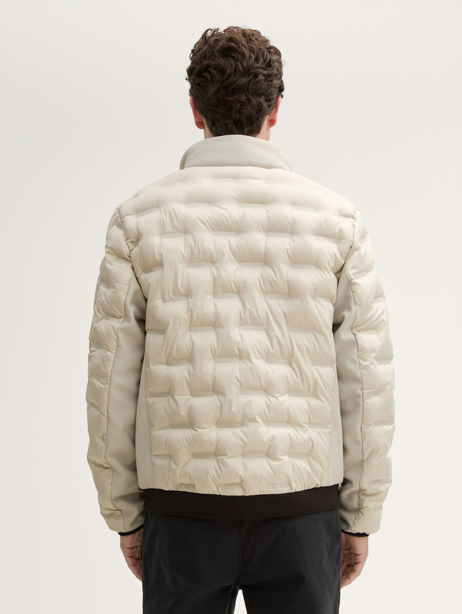 chaqueta acolchada ligera híbrida con capucha y cuello alto.