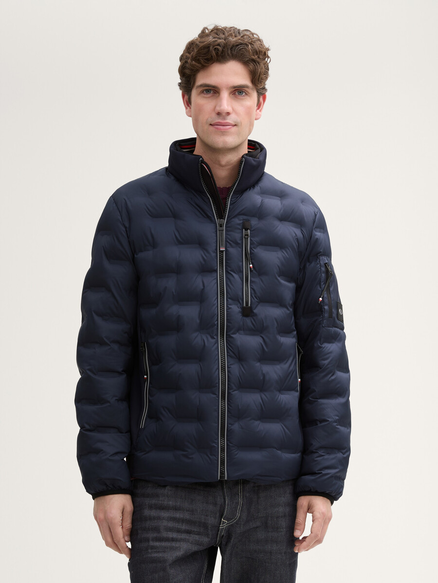 chaqueta acolchada ligera híbrida con capucha y cuello alto.