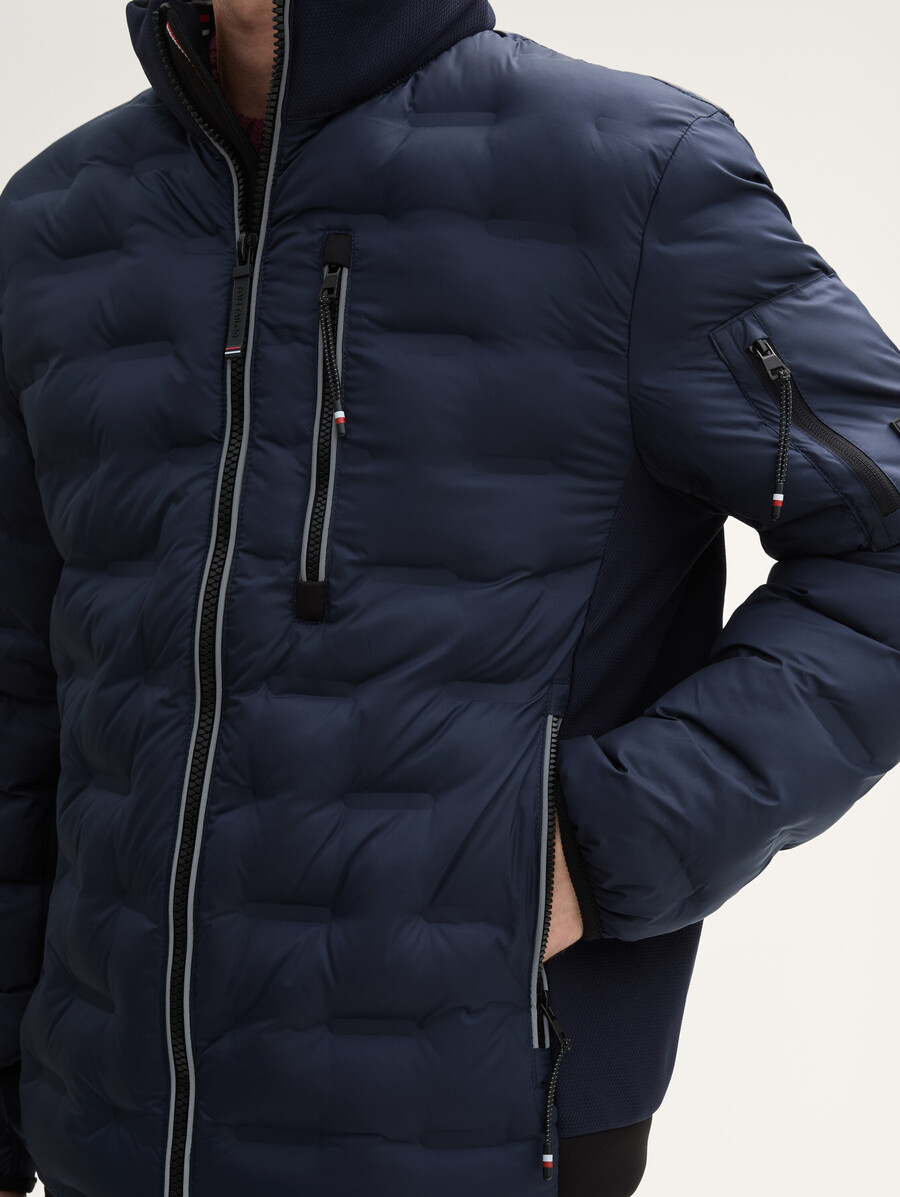 chaqueta acolchada ligera híbrida con capucha y cuello alto.