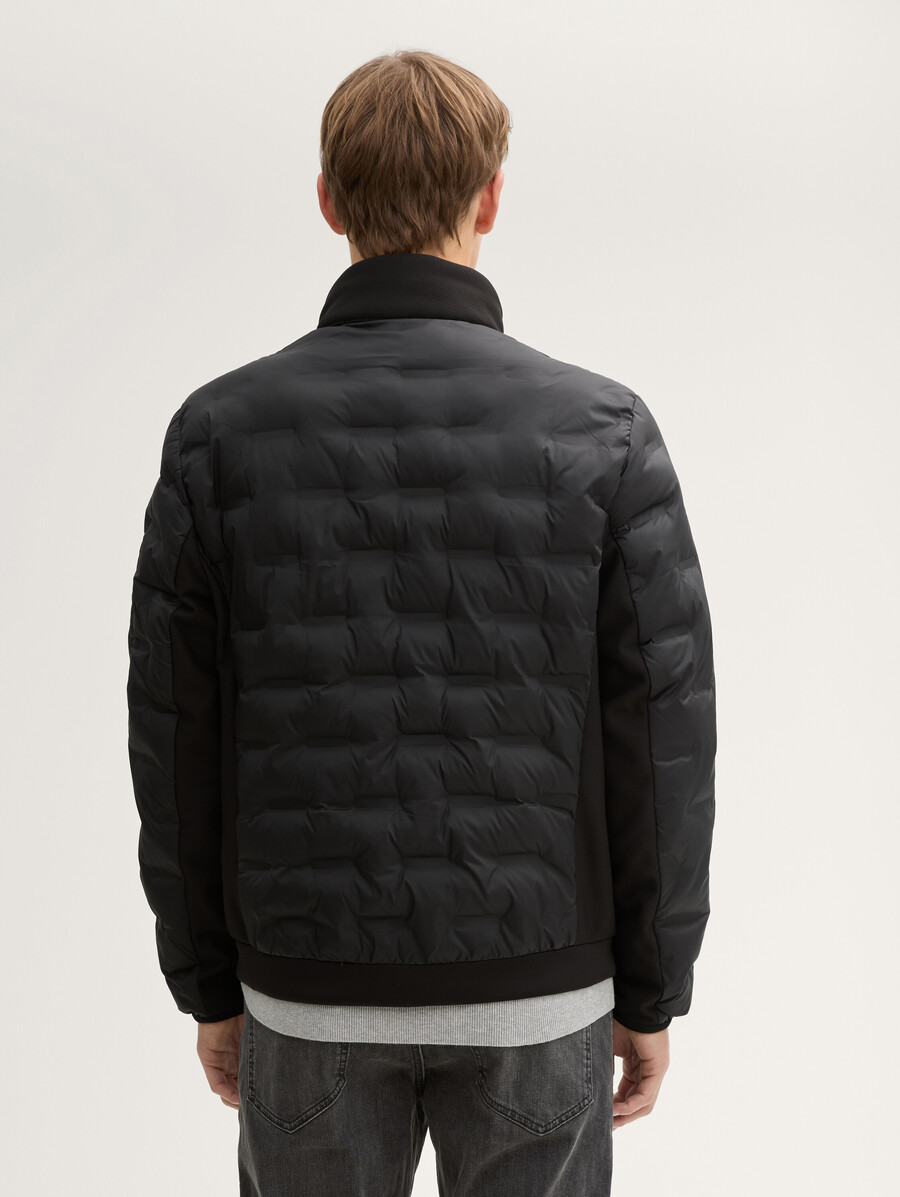 chaqueta acolchada ligera híbrida con capucha y cuello alto.