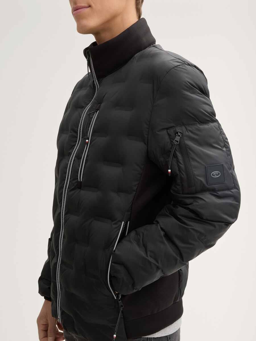 chaqueta acolchada ligera híbrida con capucha y cuello alto.