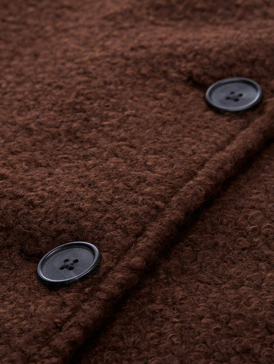 chaqueta tipo capa de bouclé con un look 2 en 1